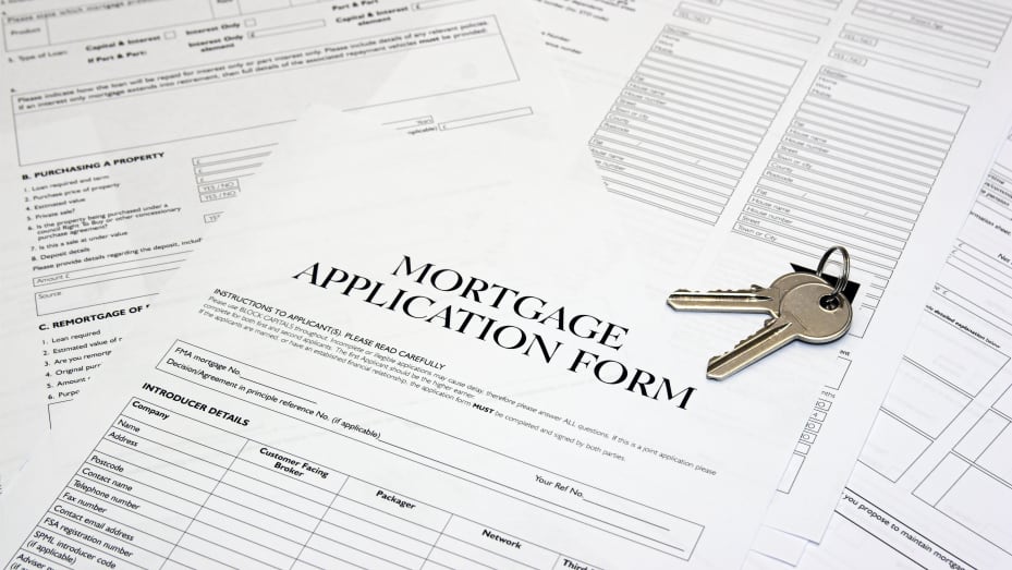 A mortgage application form with keys to new house