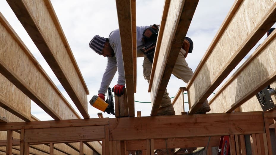 Un trabajador perfora madera contrachapada en una casa unifamiliar en construcción en Lehi, Utah, el viernes 7 de enero de 2022.
