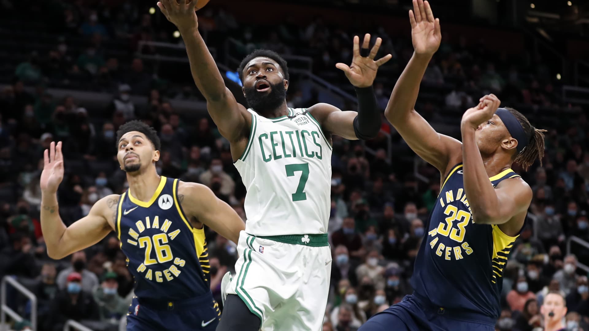 The Celtics Jaylen Brown drives to the basket between the Pacers Jeremy Lamb (left) and Myles Turner (right) in a regular season NBA basketball game at TD Garden in Boston on Jan. 10. 2022.