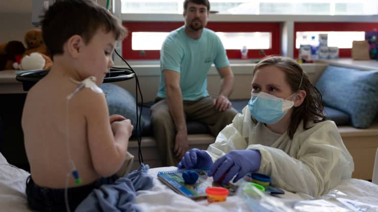 Brayden Burton, 3 tuổi, chơi với chuyên gia về cuộc sống trẻ em Maggie Kail, CCLS khi đang được điều trị bệnh do coronavirus (COVID-19) tại Bệnh viện Nhi Georgia ở Augusta, Georgia, Hoa Kỳ, ngày 14 tháng 1 năm 2022. Hannah Beier | Reuters