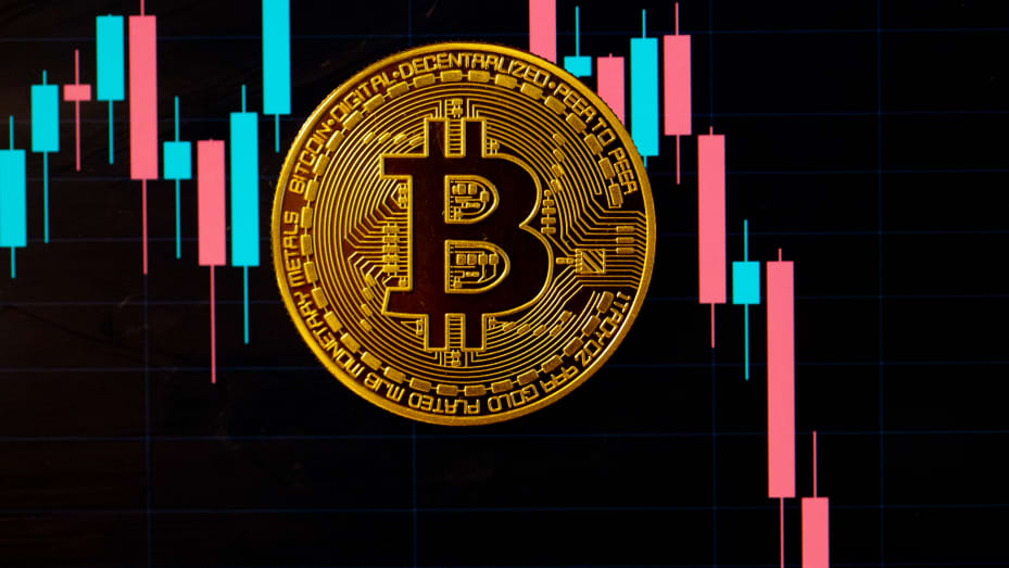 Một đồng Bitcoin nằm trên màn hình hiển thị tỷ giá hối đoái Bitcoin - đô la Mỹ.