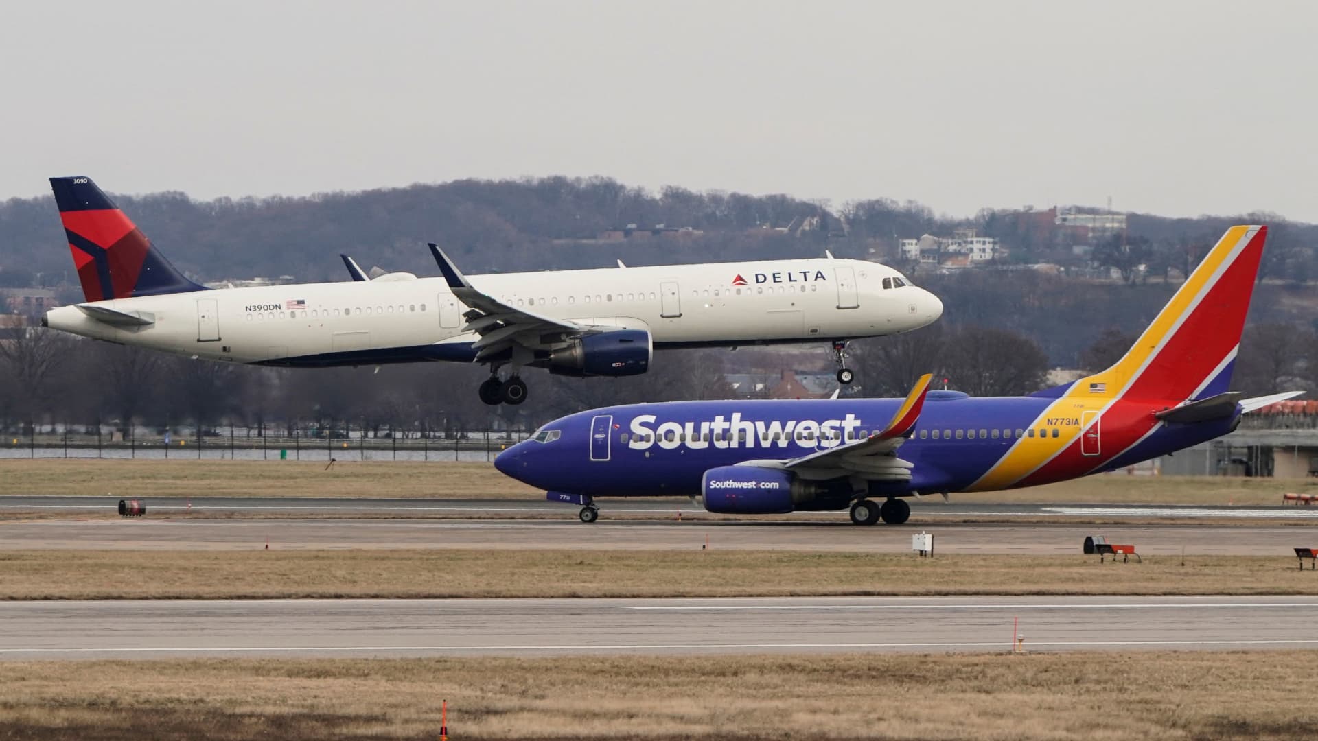 A Southwest Airlines aircraft taxis as a Delta Air Lines aircraft lands at Reagan National Airport in Arlington, Virginia, U.S., January 24, 2022.