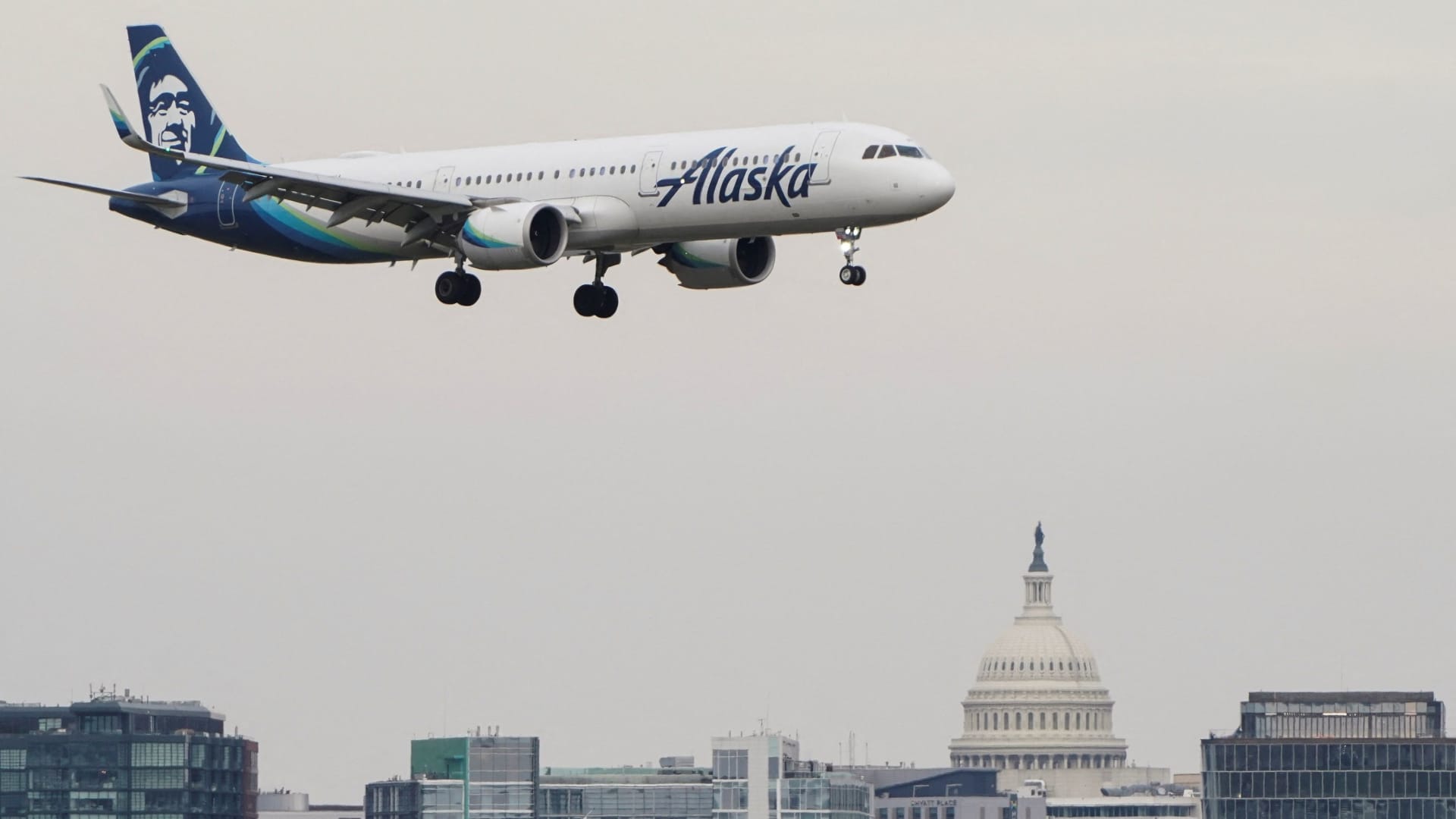 An Alaska Airlines aircraft flies past the U.S. Capitol before landing at Reagan National Airport in Arlington, Virginia, U.S., January 24, 2022.