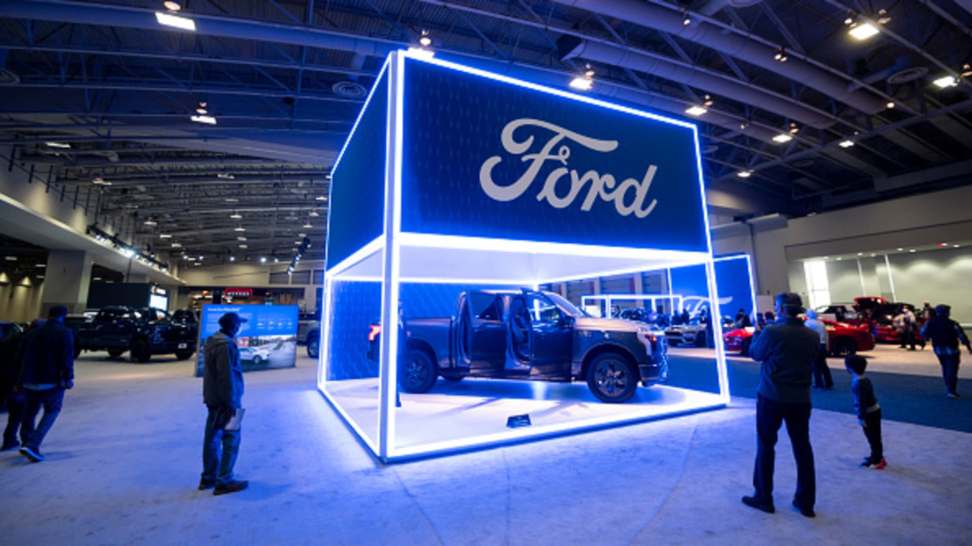 Attendees look at the all-electric Ford F-150 Lightning pickup truck at the Washington Auto Show in Washington on Tuesday, January 25, 2022.