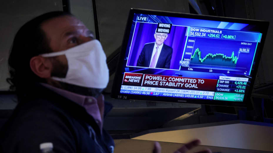 A trader works, as Federal Reserve Chair Jerome Powell is seen delivering remarks on a screen, on the floor of the New York Stock Exchange (NYSE), January 26, 2022.