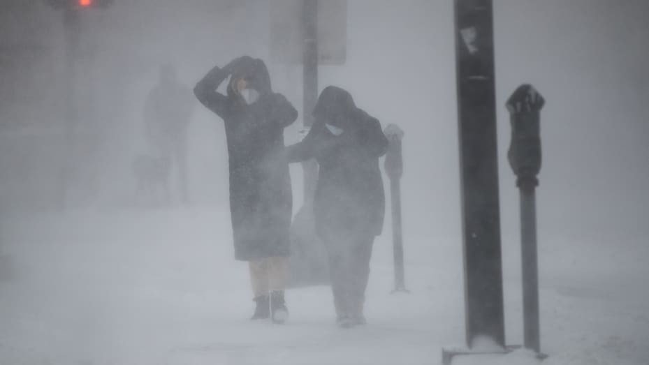 People protect themselves from blowing wind and snow during white-out conditions as Winter Storm Kenan bears down on January 29, 2022 in Boston, Massachusetts.