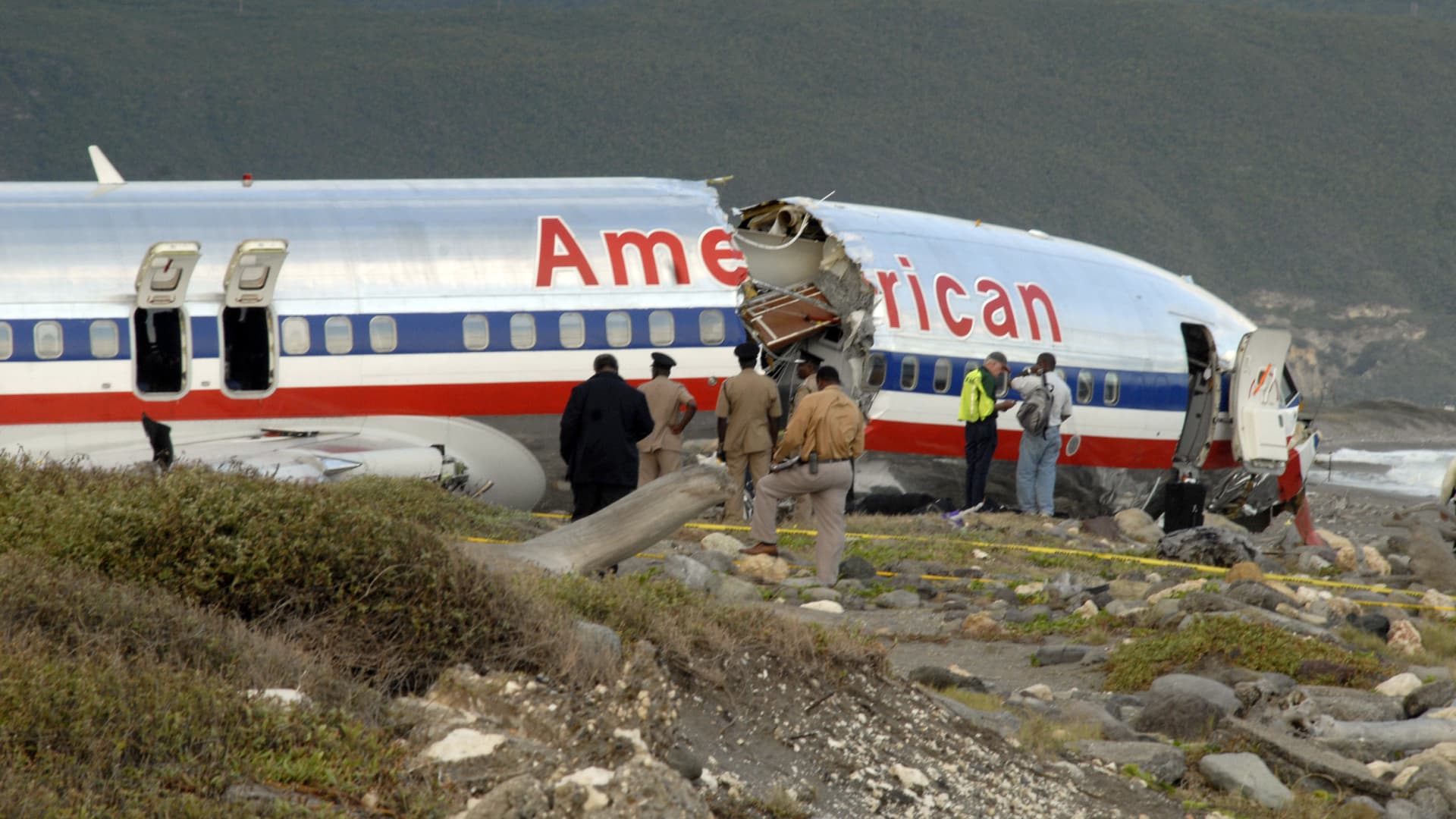 Officials examine the remains of American Airlines Flight AA331 at the Kingston airport December 23, 2009.