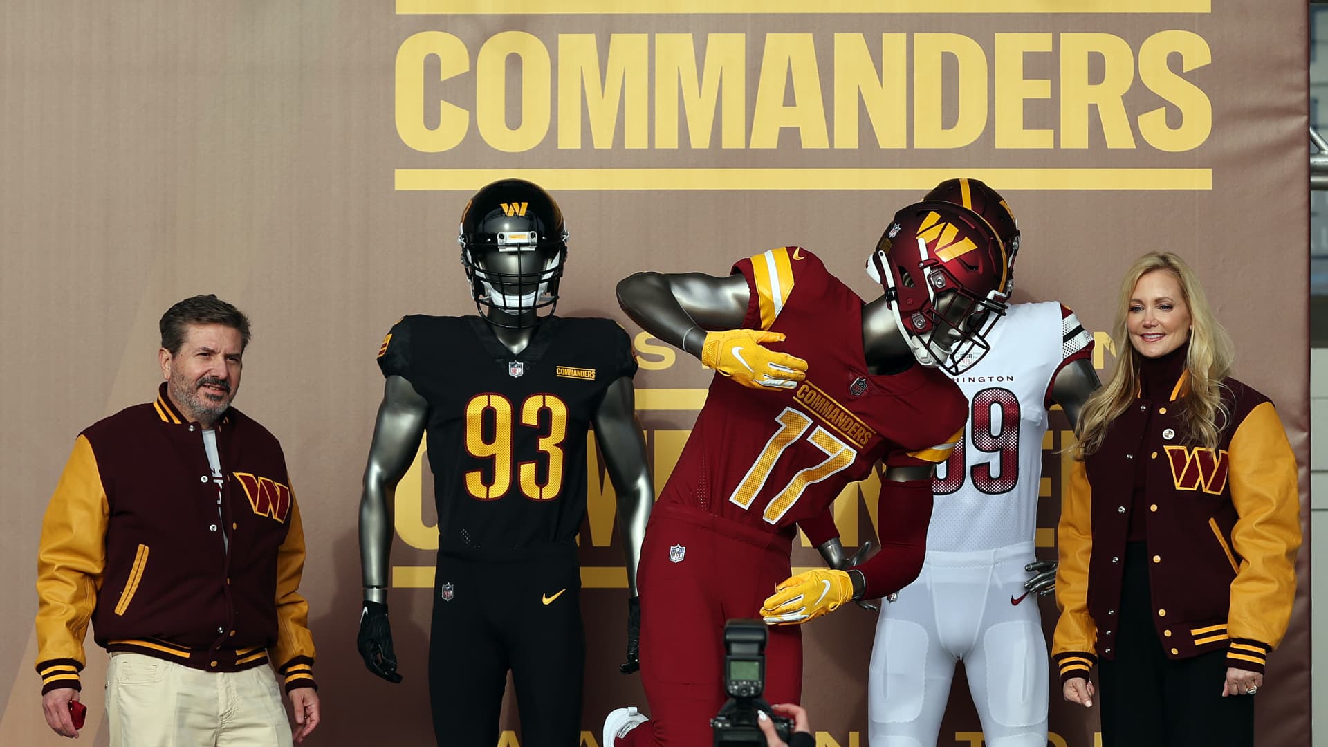 Team co-owners Dan and Tanya Snyder pose for a photo with the new team uniforms during the announcement of the Washington Football Team's name change to the Washington Commanders at FedExField on February 02, 2022 in Landover, Maryland.