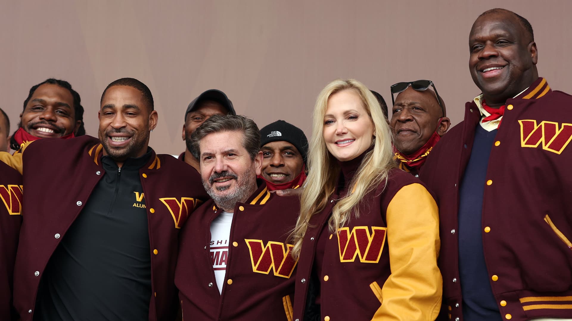 Team co-owners Dan and Tanya Snyder pose for a photo with current team members and alumni during the announcement of the Washington Football Team's name change to the Washington Commanders at FedExField on February 02, 2022 in Landover, Maryland.