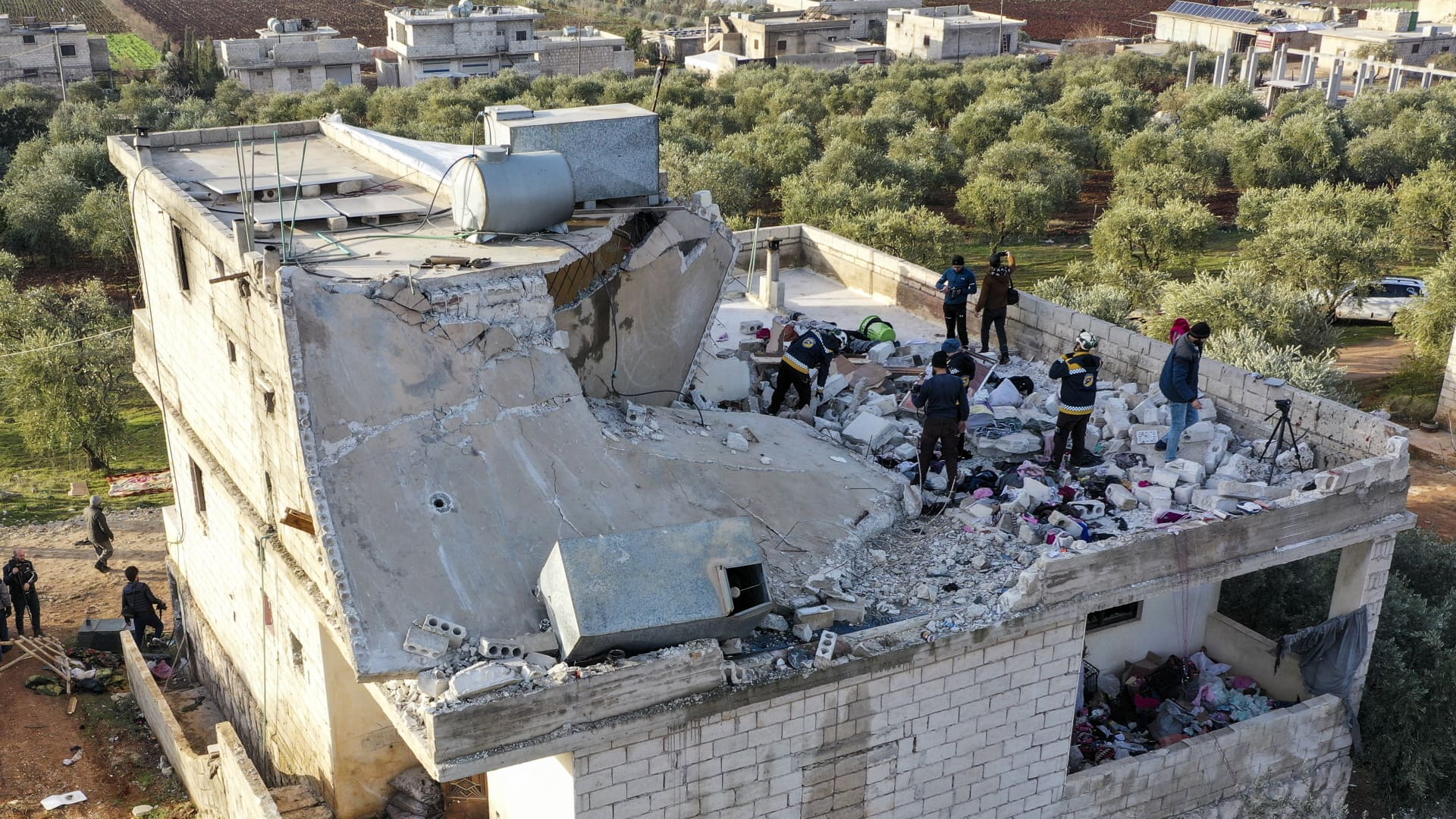 People inspect a destroyed house following an operation by the U.S. military in the Syrian village of Atmeh, in Idlib province, Syria, Thursday, Feb. 3, 2022.