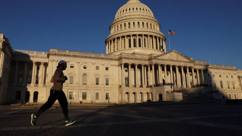 A person runs in front of the U.S. Capitol building during morning hours in Washington, February 10, 2022.