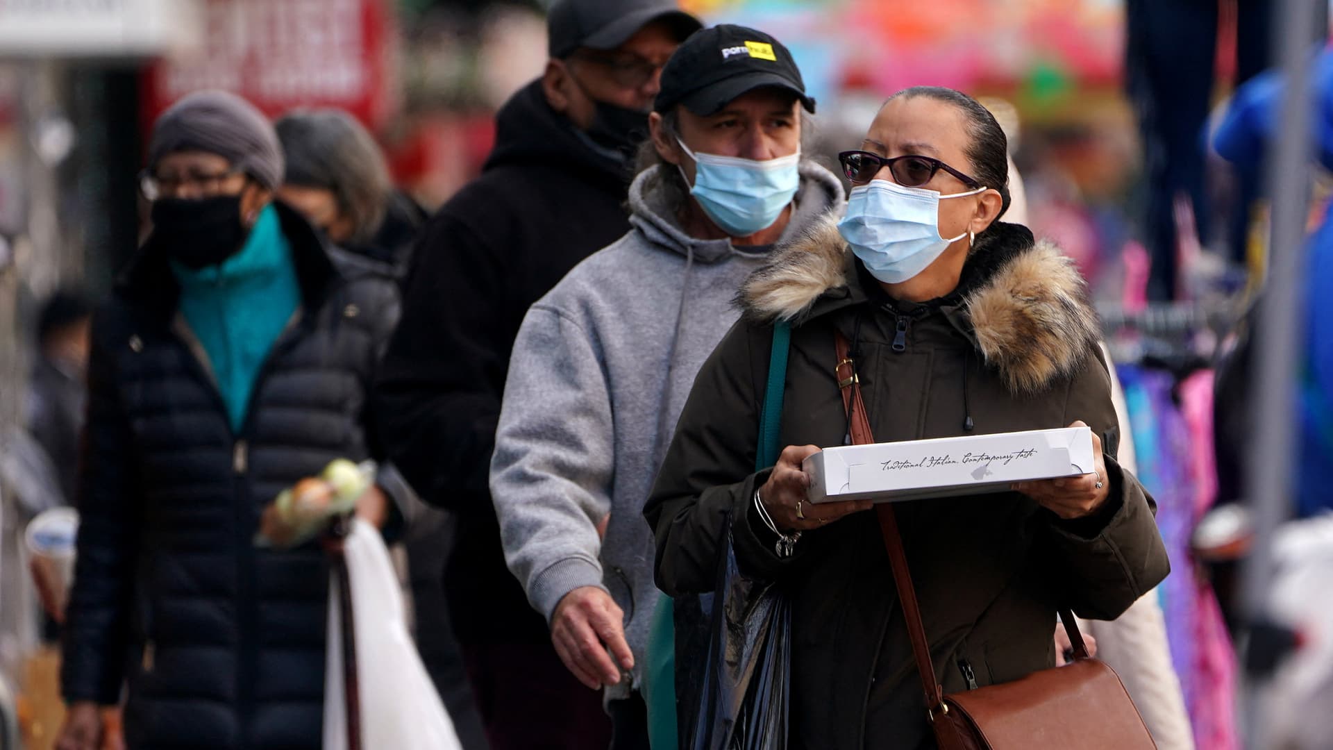 People walk outside wearing masks during the coronavirus disease (COVID-19) pandemic in the Harlem area of the Manhattan borough of New York City, New York, February 10, 2022.