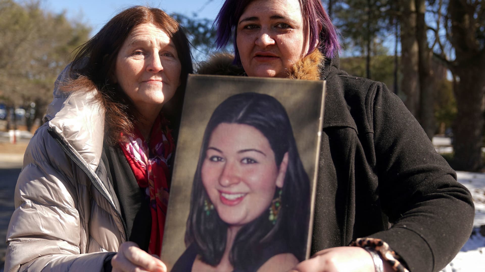 Mary D'Avino and Hannah Miranda, the mother and sister of Rachel D'Avino, a Sandy Hook Elementary School shooting victim, hold a photo of her as they pose for a portrait following a press conference to announce a settlement with Remington Arms in Trumbull, Connecticut, U.S., February 15, 2022.