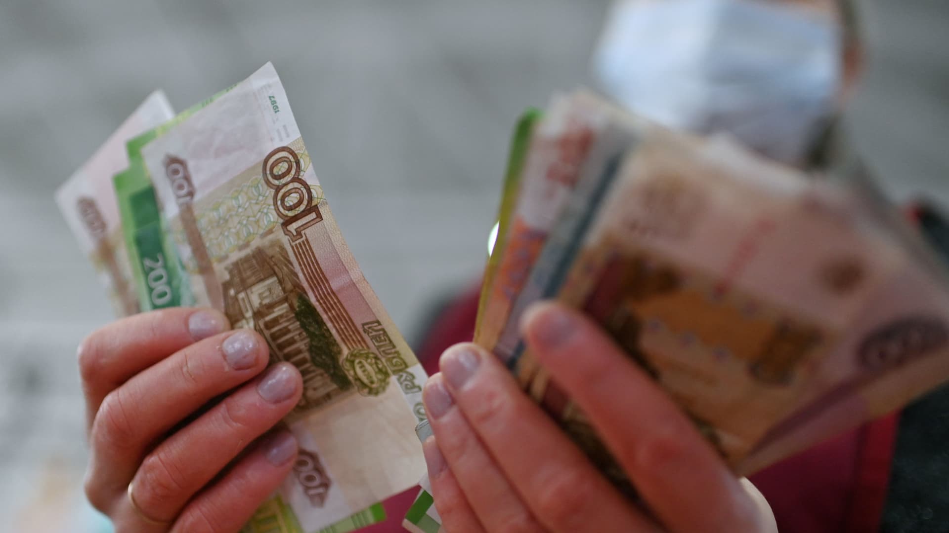 A vendor counts Russian rouble banknotes at a market in Omsk, Russia February 18, 2022.