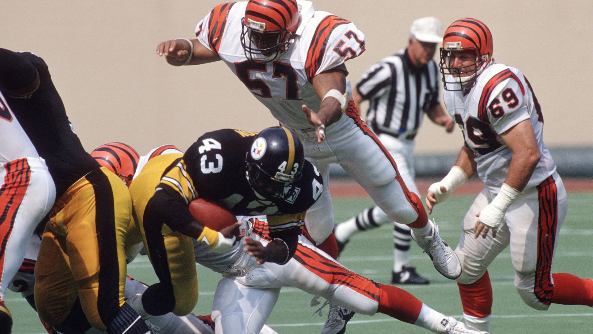 Reggie Williams #57 of the Cincinnati Bengals dives on top of Earnest Jackson #43 of the Pittsburgh Steelers during an NFL football game September 18, 1988 at Three Rivers Stadium in Pittsburgh, Pennsylvania. Williams played for the Bengals from 1976-89.
