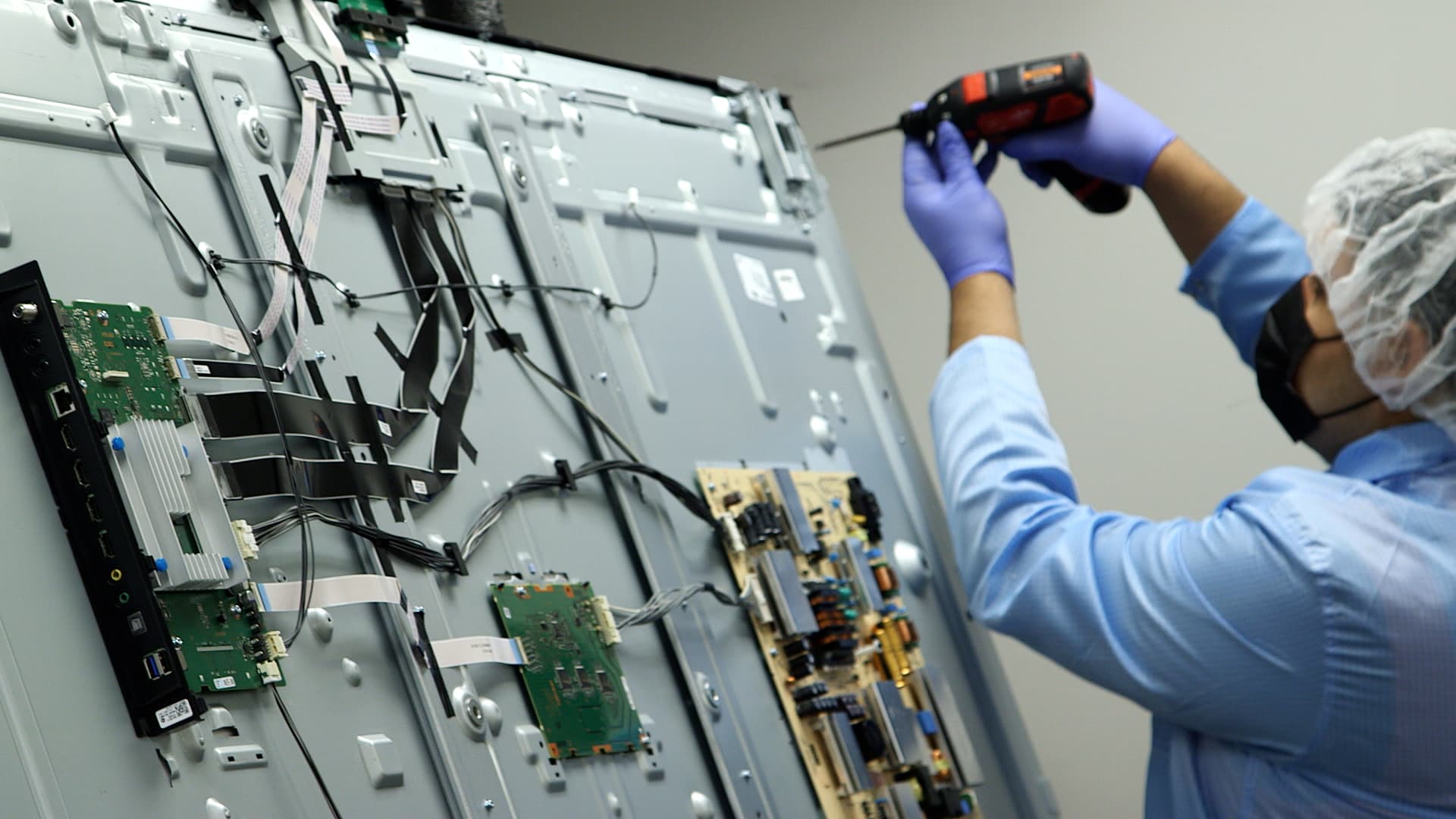 A Liquidity Services employee refurbishes a TV at a warehouse in Garland, Texas, on January 31, 2022.