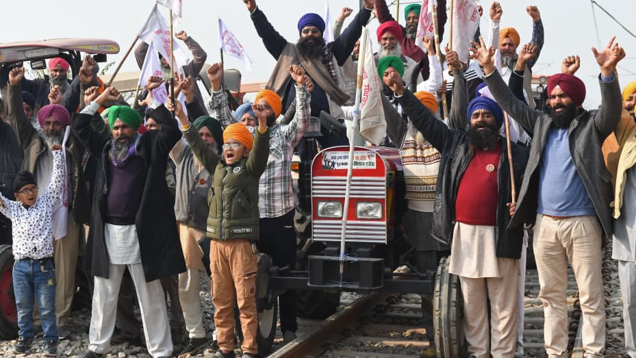 Los agricultores gritan consignas mientras bloquean las vías del tren durante una manifestación exigiendo compensaciones y empleos para las familias de quienes murieron durante las protestas contra las reformas agrícolas del gobierno central en las afueras de Amritsar el 24 de diciembre.