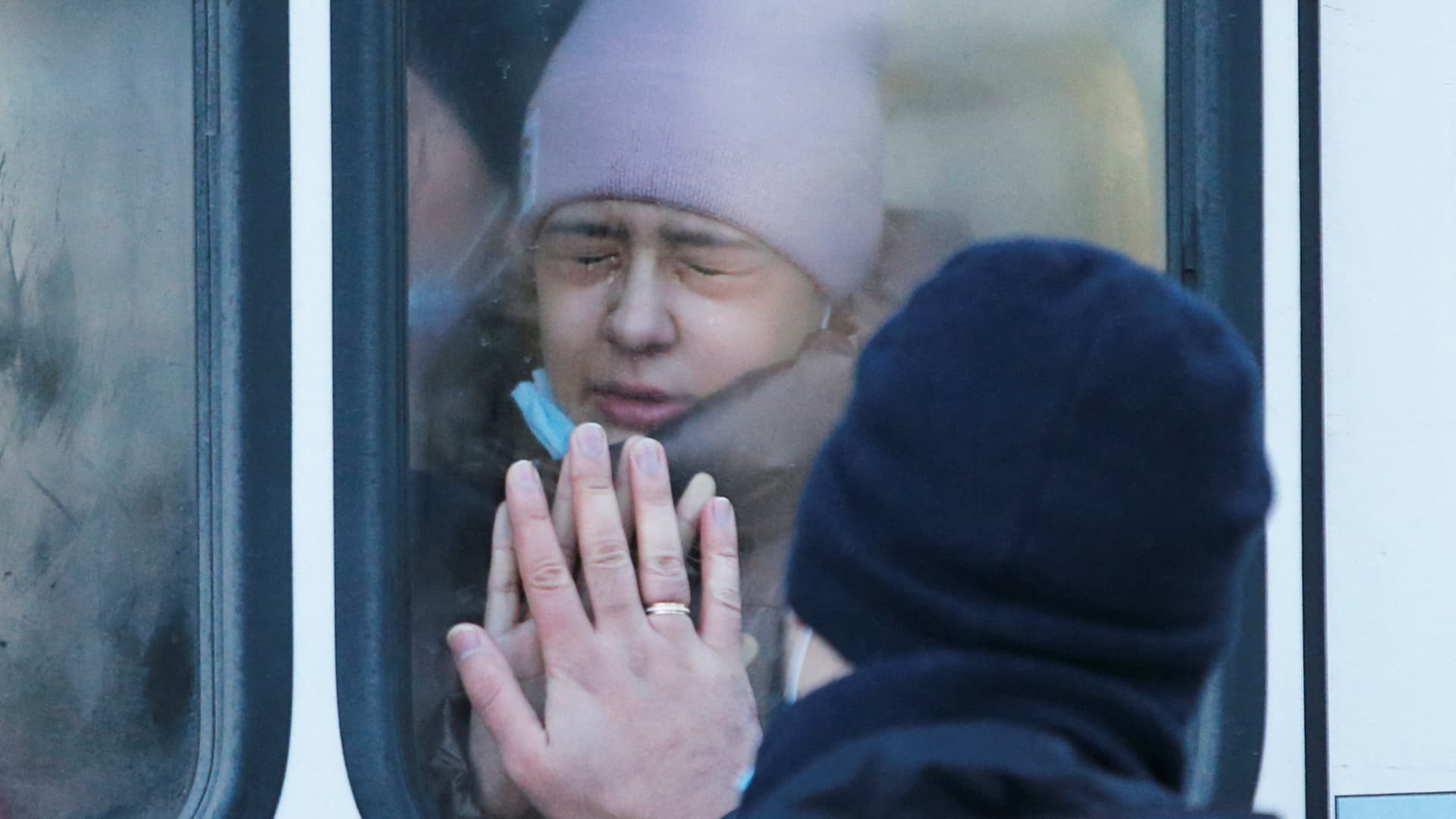 A woman says goodbye to her father through a bus window during the evacuation of local residents to Russia, in the rebel-controlled city of Donetsk, Ukraine February 19, 2022.