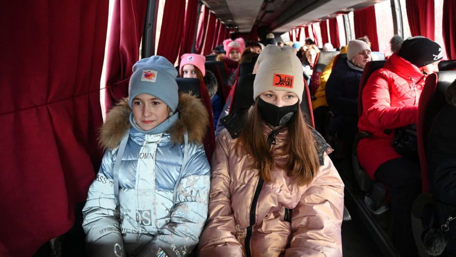 People, who were evacuated from separatist-controlled regions in eastern Ukraine, sit in a bus as they arrive at a railway station to leave the city of Taganrog in the Rostov region, Russia February 20, 2022.