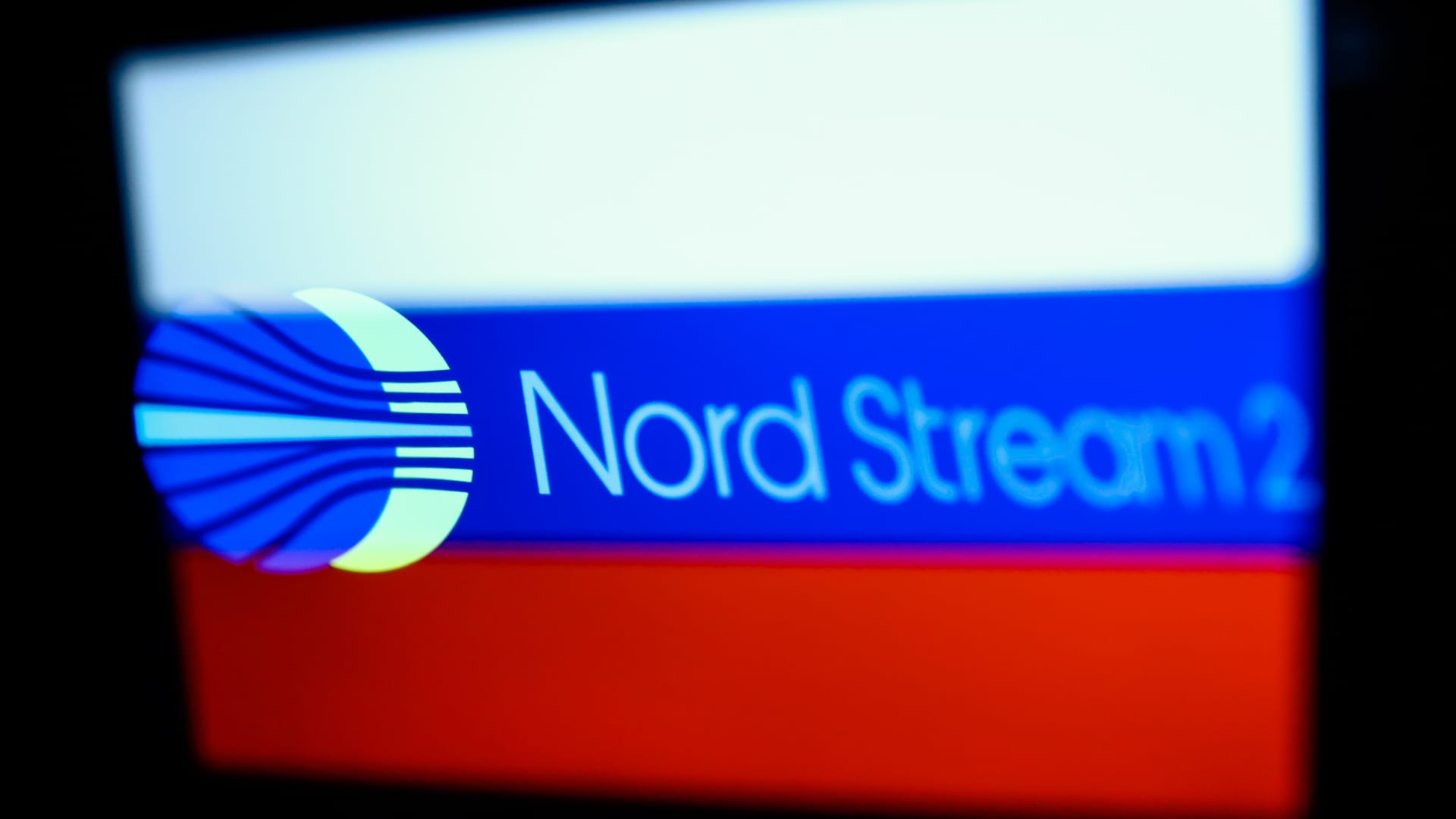 Nord Stream 2 logo displayed on a phone screen and Russian flag displayed on a laptop screen are seen in this multiple exposure illustration photo taken in Krakow in Krakow, Poland on February 22, 2022.