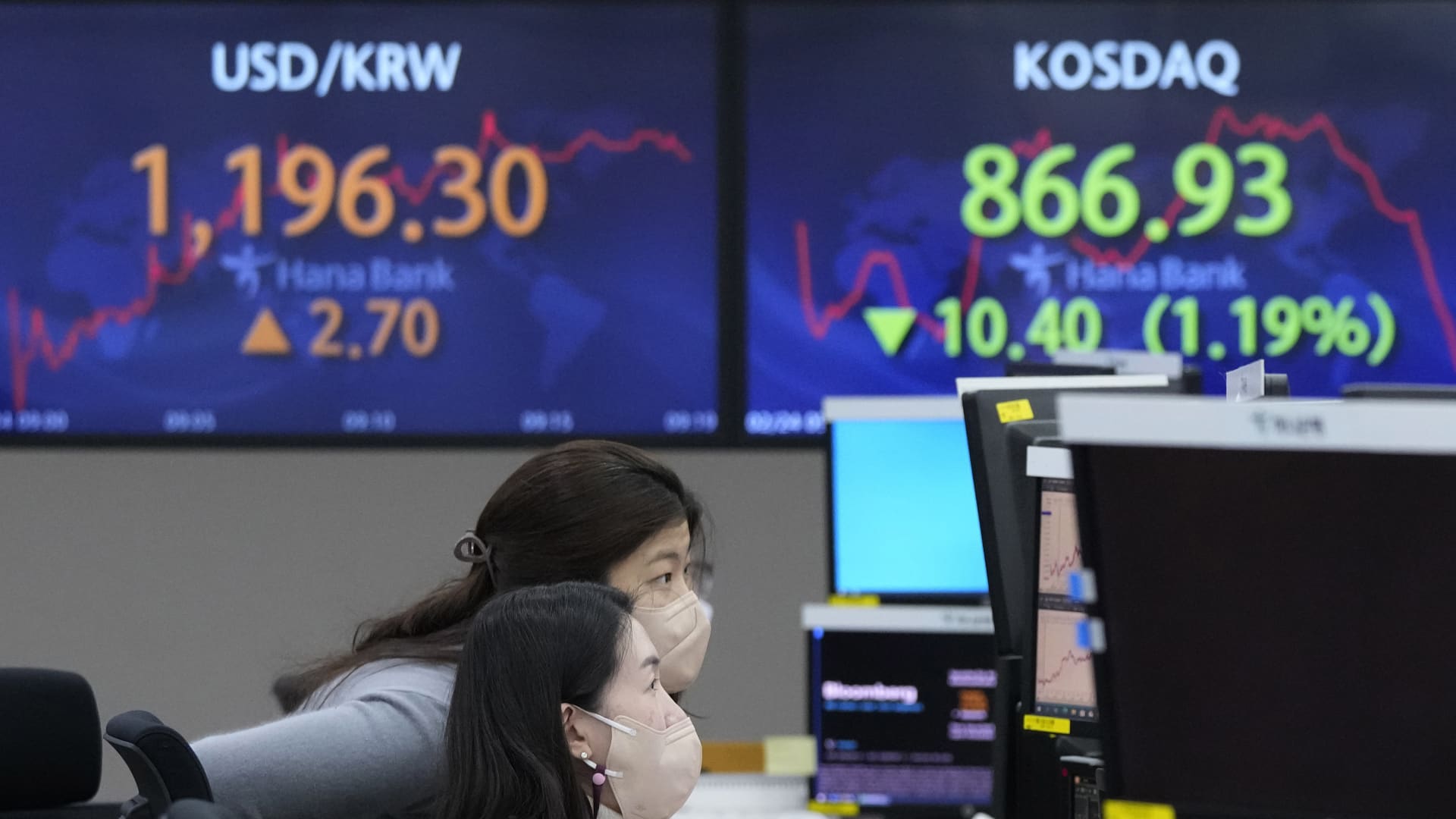 Currency traders watch monitors at the foreign exchange dealing room of the KEB Hana Bank headquarters in Seoul, South Korea, Thursday, Feb. 24, 2022.