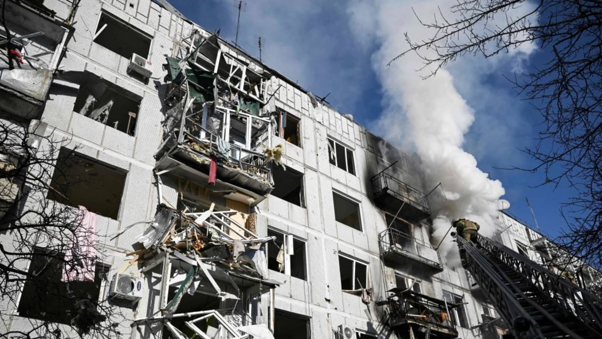 Firefighters work on a fire on a building after bombings on the eastern Ukraine town of Chuguiv on February 24, 2022, as Russian armed forces are trying to invade Ukraine from several directions.