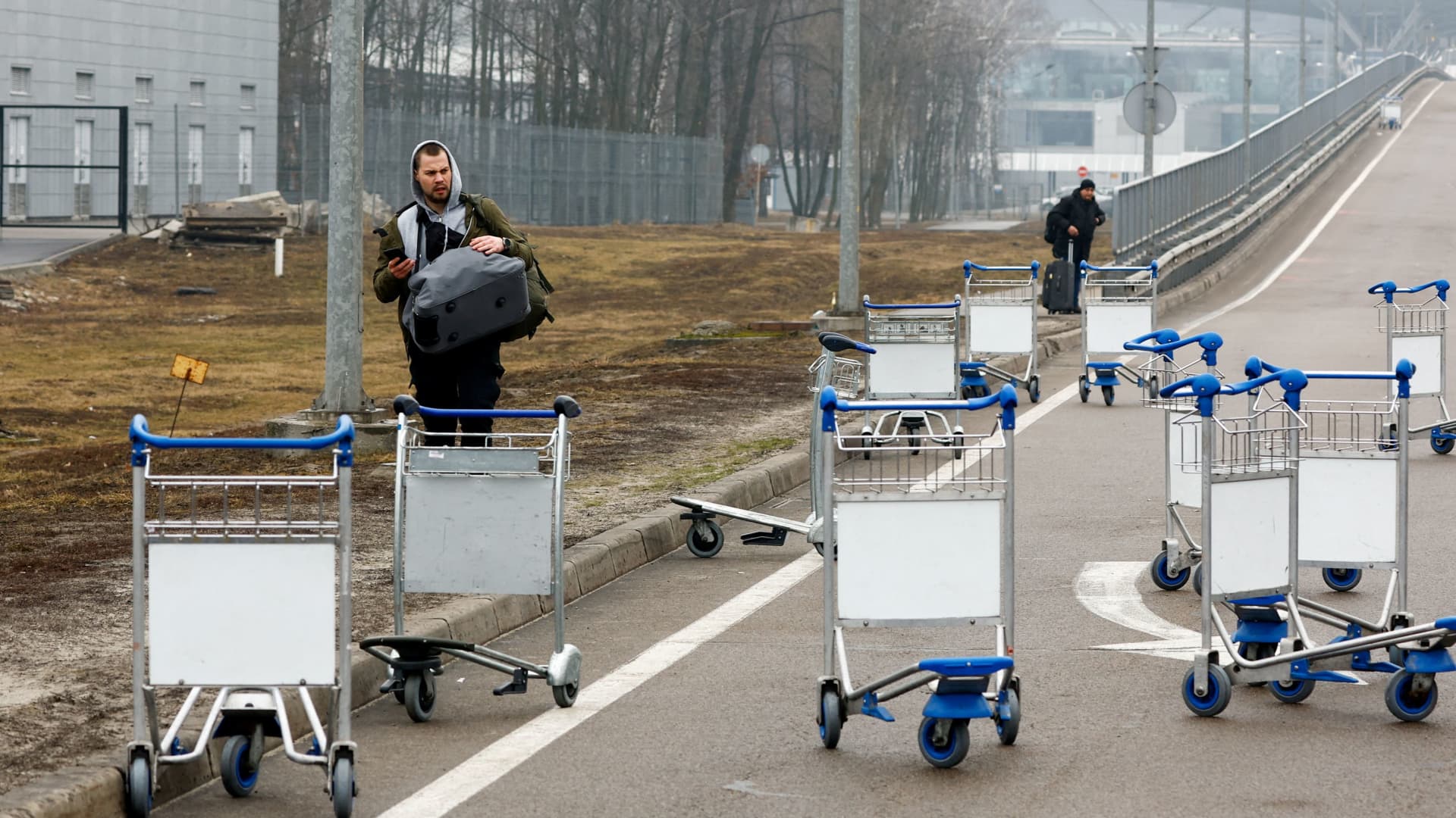 A person walks past luggage carts at Boryspil International Airport after Russian President Vladimir Putin authorized a military operation in eastern Ukraine, February 24, 2022.