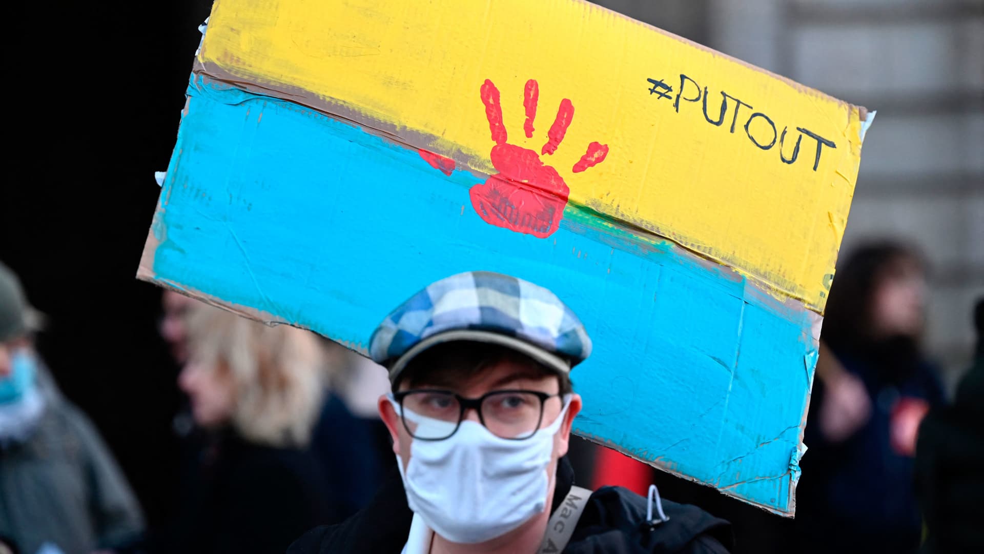 A protester holds a placard in the colour of the Ukrainian flag during a rally against Russia's military operation in Ukraine during a rally in Rennes, western France on February 24, 2022.
