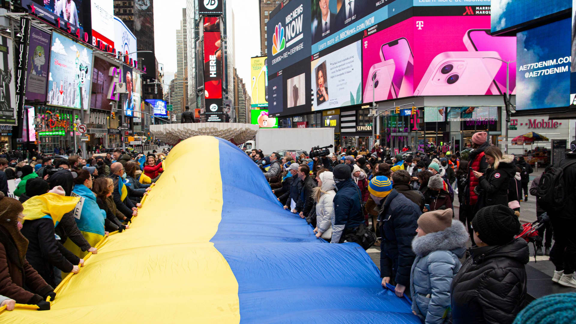 Demonstrators hold a Ukrainian flag as they protest in support of Ukraine, in Times Square New York, on February 24, 2022.