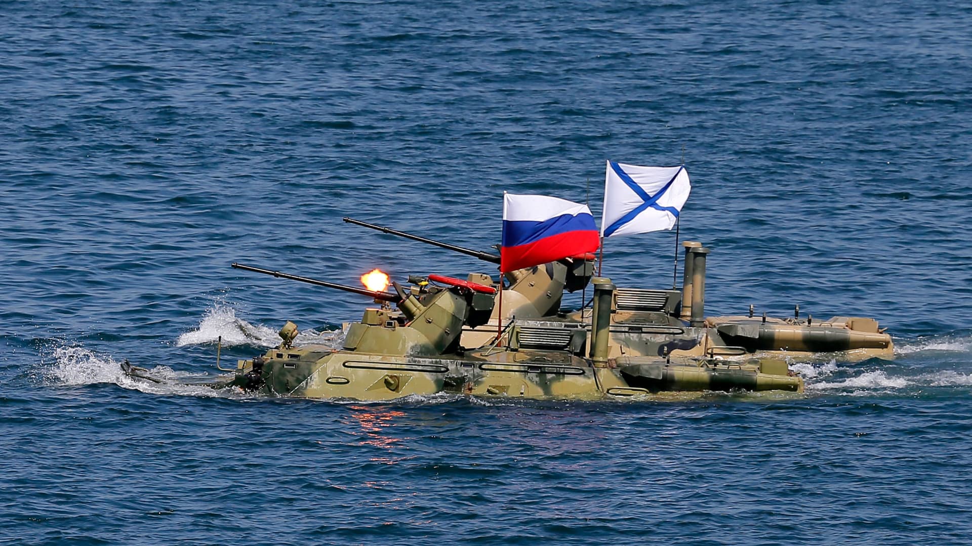 Russian armoured personnel carriers sail after submerging from an amphibious assault ship during a parade as part of the Navy Day celebration in Sevastopol on July 28, 2019.