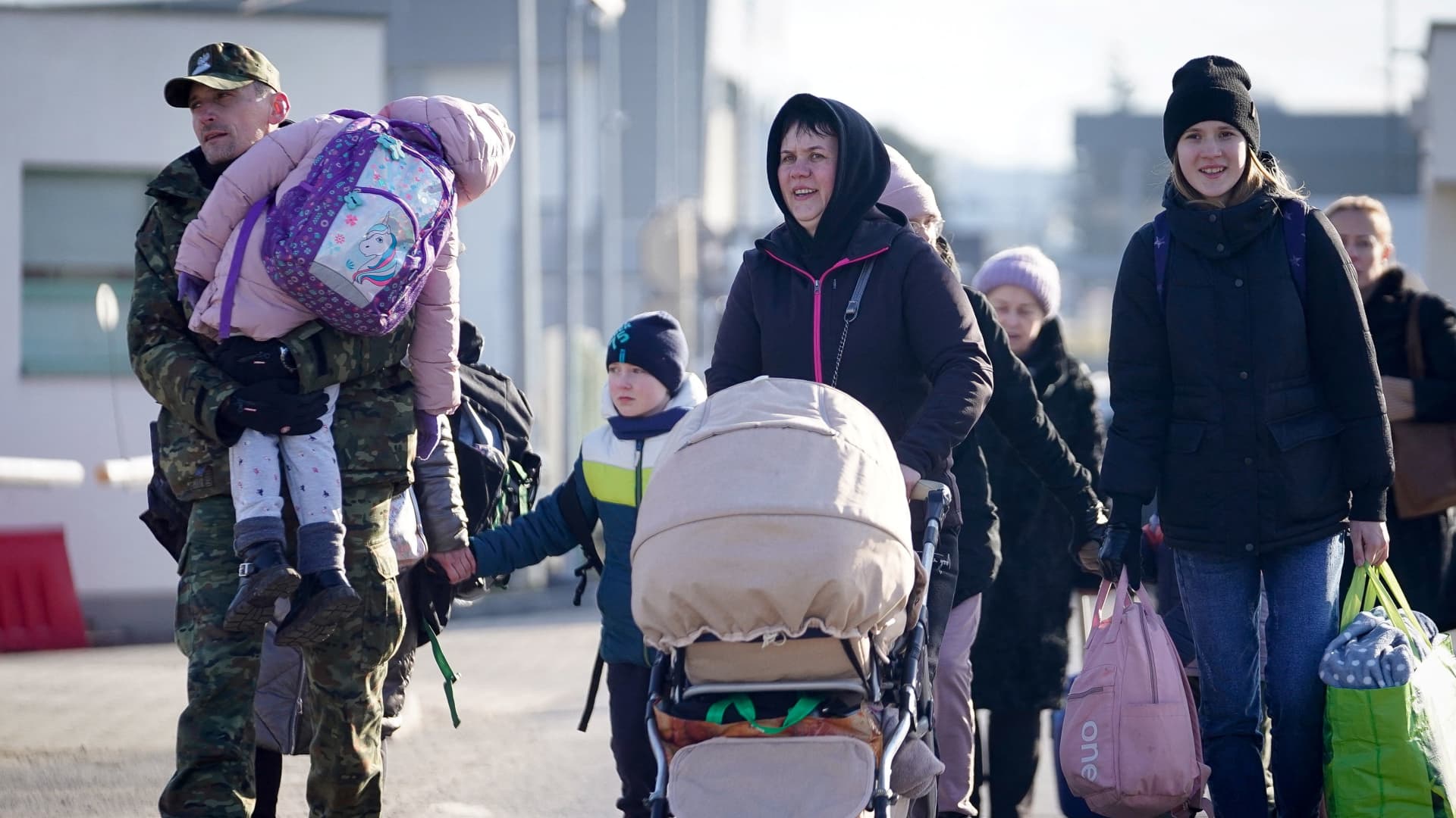 A Polish border guard carries a child across the border after Russia launched a massive military operation against Ukraine that forced her family to flee their home, in Medyka, Poland, February 26, 2022.