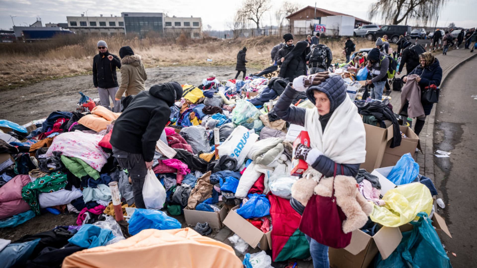After crossing the border from Shehyni in Ukraine to Medyka in Poland, refugees seek clothing and blankets provided by Polish volunteers from police officers.