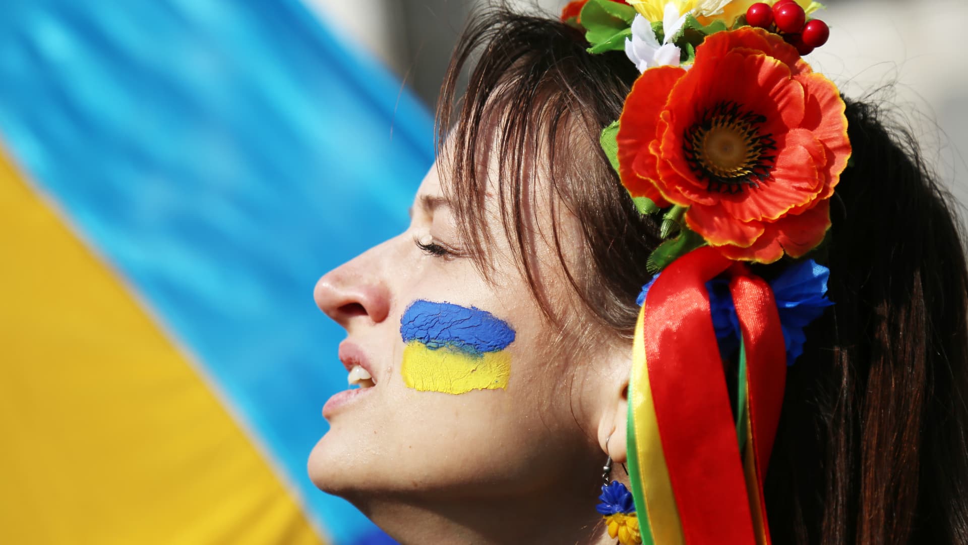 A protester with a Ukrainian flag on her face is seen during the demonstration against Russian aggression.