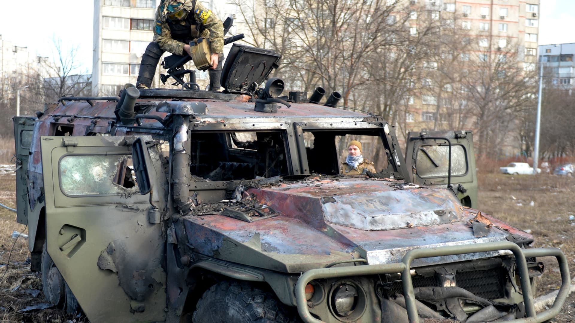 Ukrainian soldiers examine a destroyed Russian infantry vehicle on February 27, 2022.