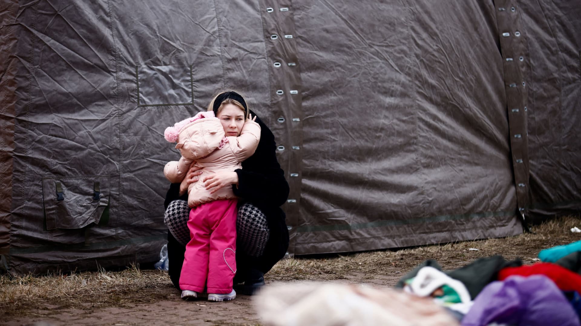 A woman fleeing Russian invasion of Ukraine hugs a child at a temporary camp in Przemysl, Poland, February 28, 2022.