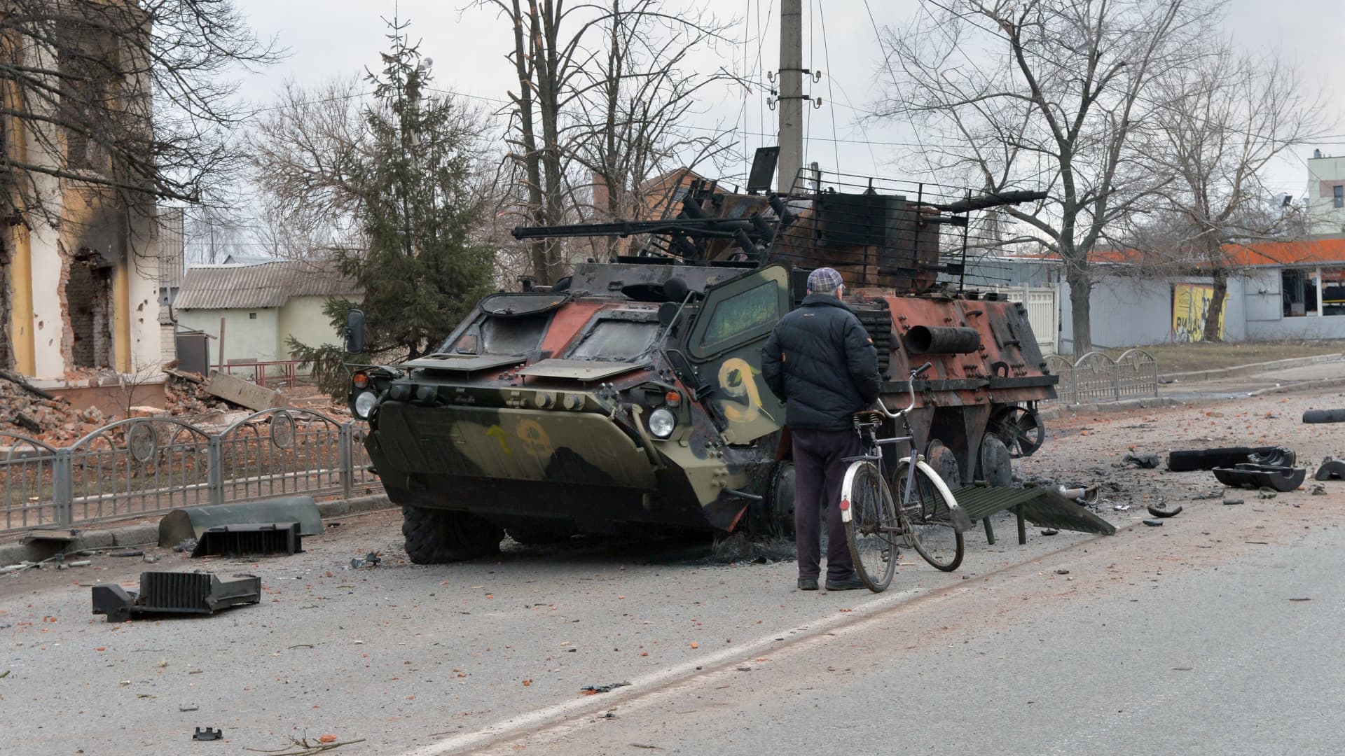 A man looks at an Ukrainian armored personnel carrierBTR-4 destroyed as a result of fight not far from the center of Ukrainian city of Kharkiv, located some 50 km from Ukrainian-Russian border, on February 28, 2022.