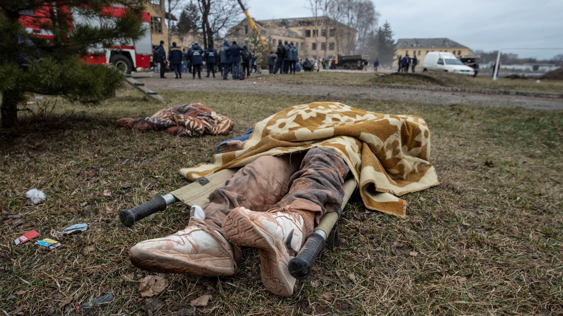 SENSITIVE MATERIAL. THIS IMAGE MAY OFFEND OR DISTURB The body of a person lies on the ground next to a military base building that, according to the Ukrainian ground forces, was destroyed by an air strike, in the town of Okhtyrka in the Sumy region, Ukraine February 28, 2022.