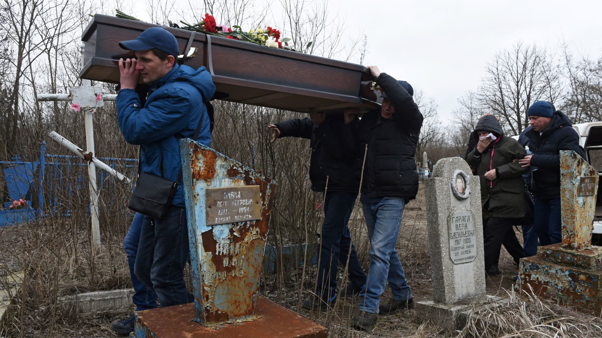 Men carry the coffin during a funeral of school teachers Yelena Ivanova and Yelena Kudrik, who were killed by shelling, at a cemetery in the separatist-controlled town of Horlivka (Gorlovka) in the Donetsk region, Ukraine, February 28, 2022.
