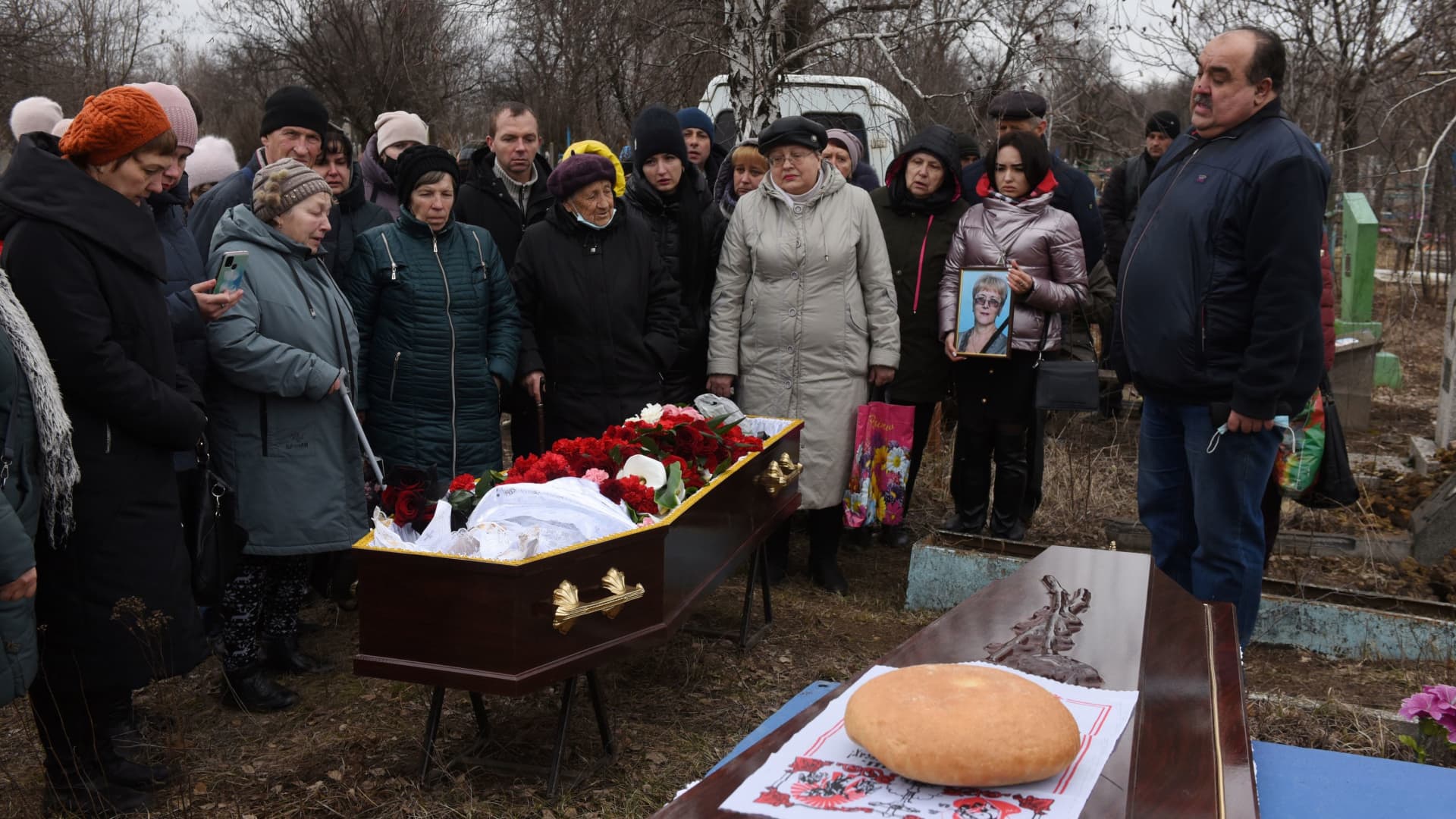 People stand near the coffin during a funeral of school teachers Yelena Ivanova and Yelena Kudrik, who were killed by shelling, at a cemetery in the separatist-controlled town of Horlivka (Gorlovka) in the Donetsk region, Ukraine, February 28, 2022.