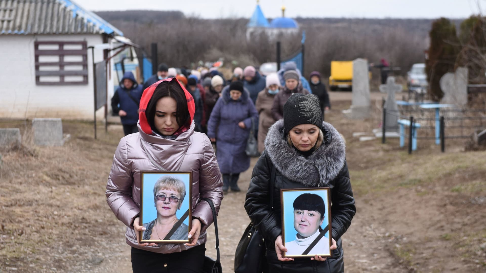Women carry portraits of school teachers Yelena Ivanova and Yelena Kudrik, who were killed by shelling, during a funeral at a cemetery in the separatist-controlled town of Horlivka (Gorlovka) in the Donetsk region, Ukraine, February 28, 2022.