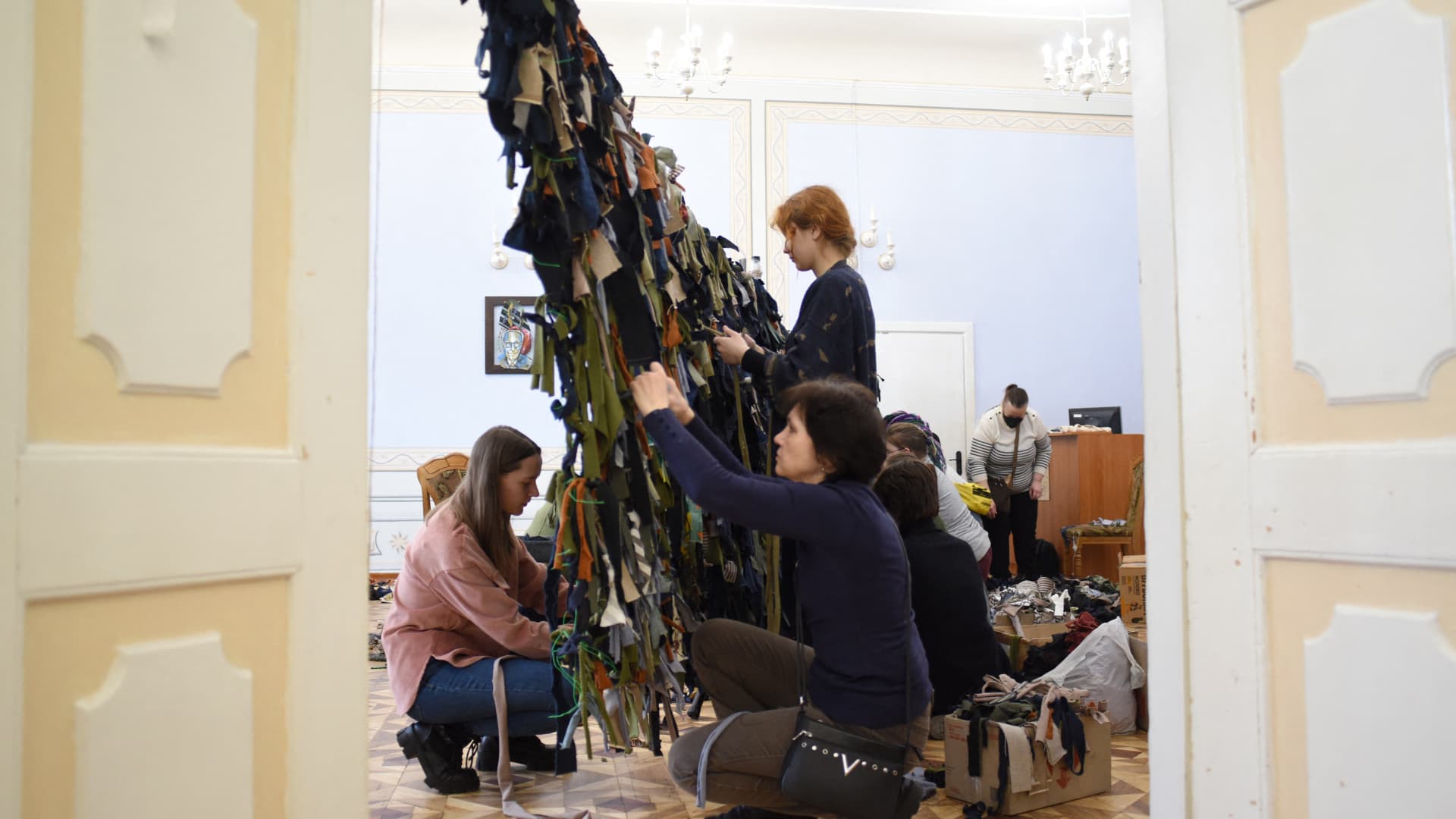 Volunteers make camouflage nets for the Ukrainian military at a library in western Ukrainian city of Lviv on March 1, 2022.