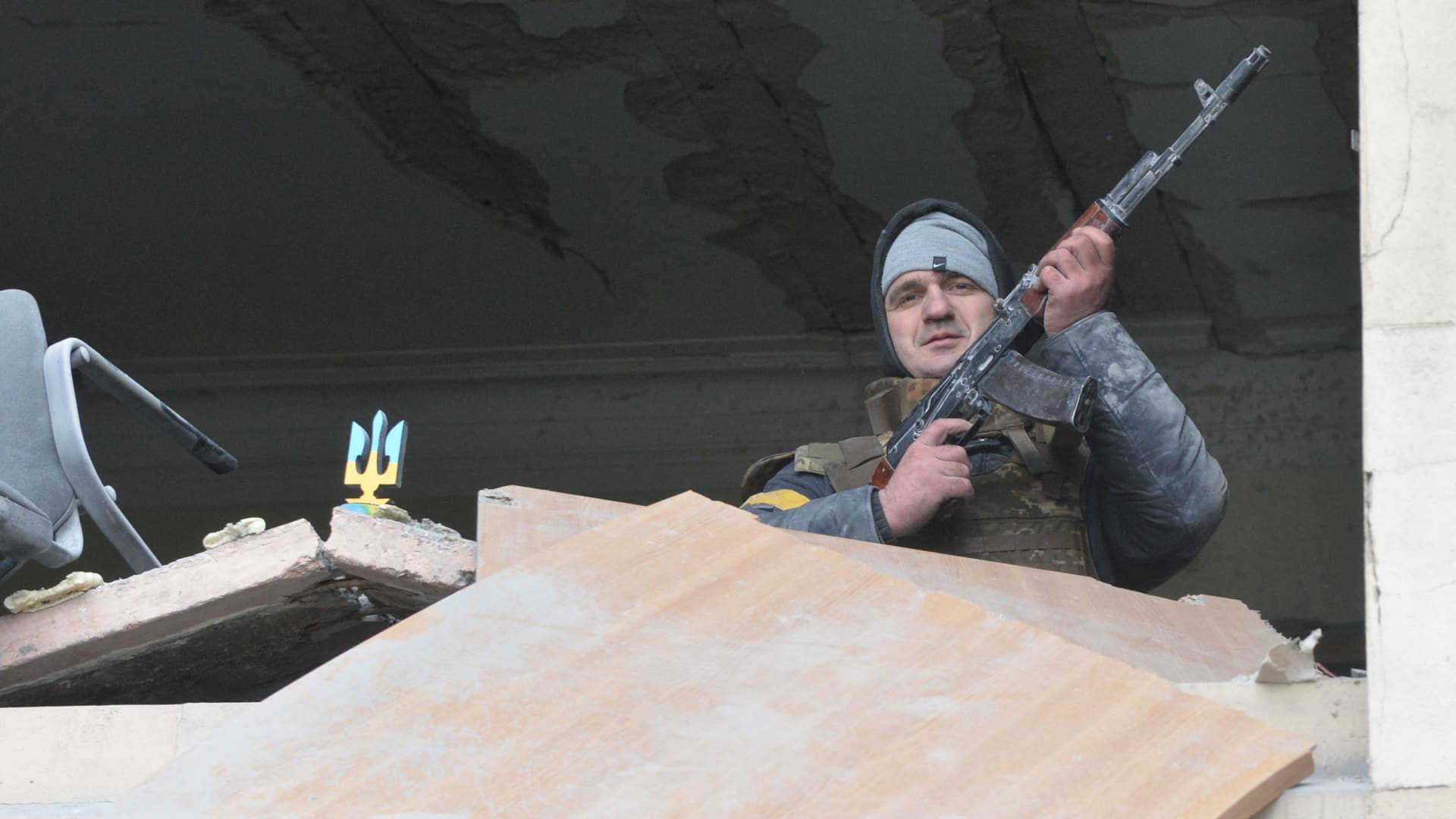 An armed man is seen inside the damaged local city hall of Kharkiv on March 1, 2022, destroyed as a result of Russian troop shelling.