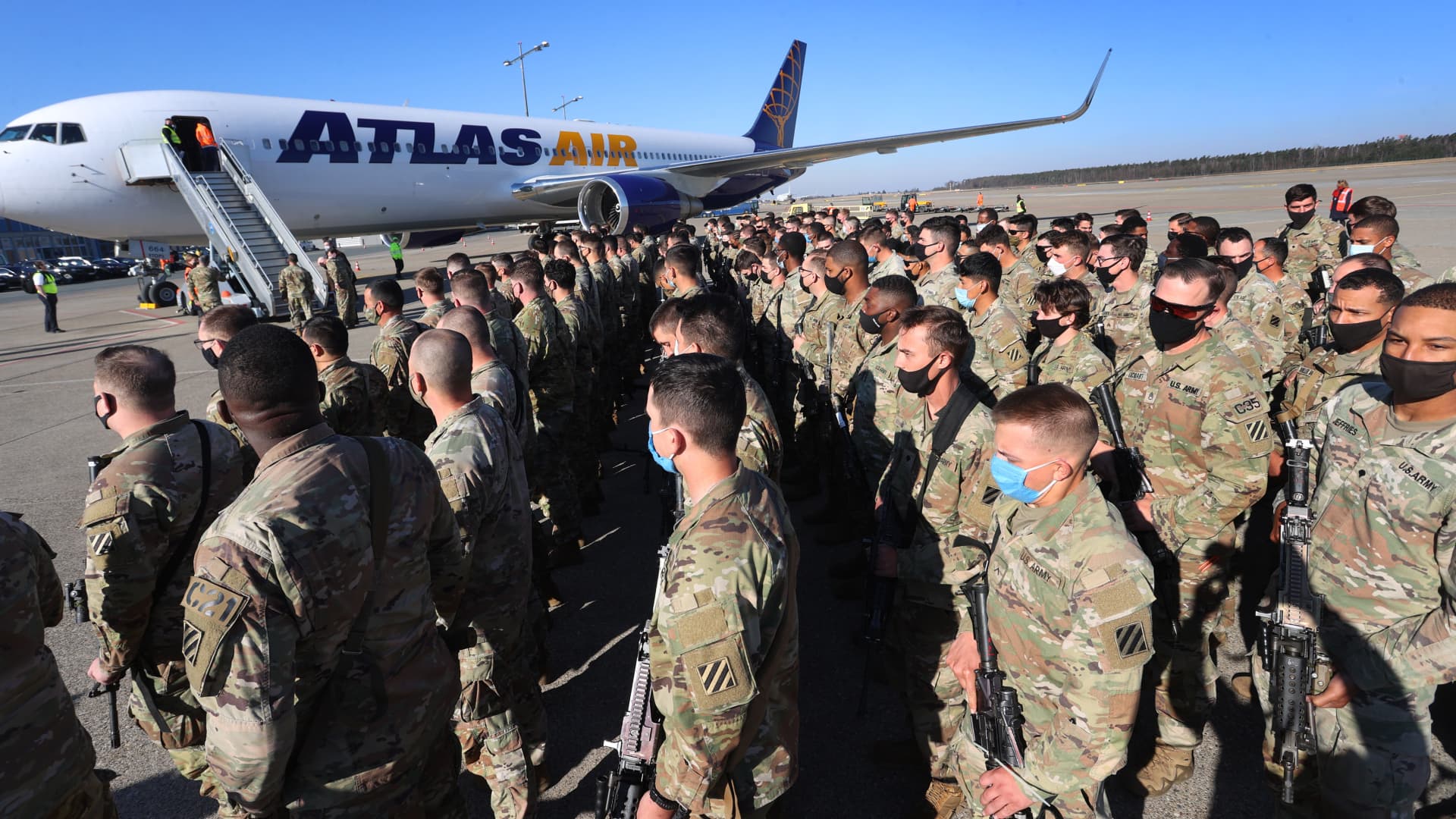 U.S. soldiers lined up at Albrecht Dürer Airport next to a Boeing 767-300 that has just landed.