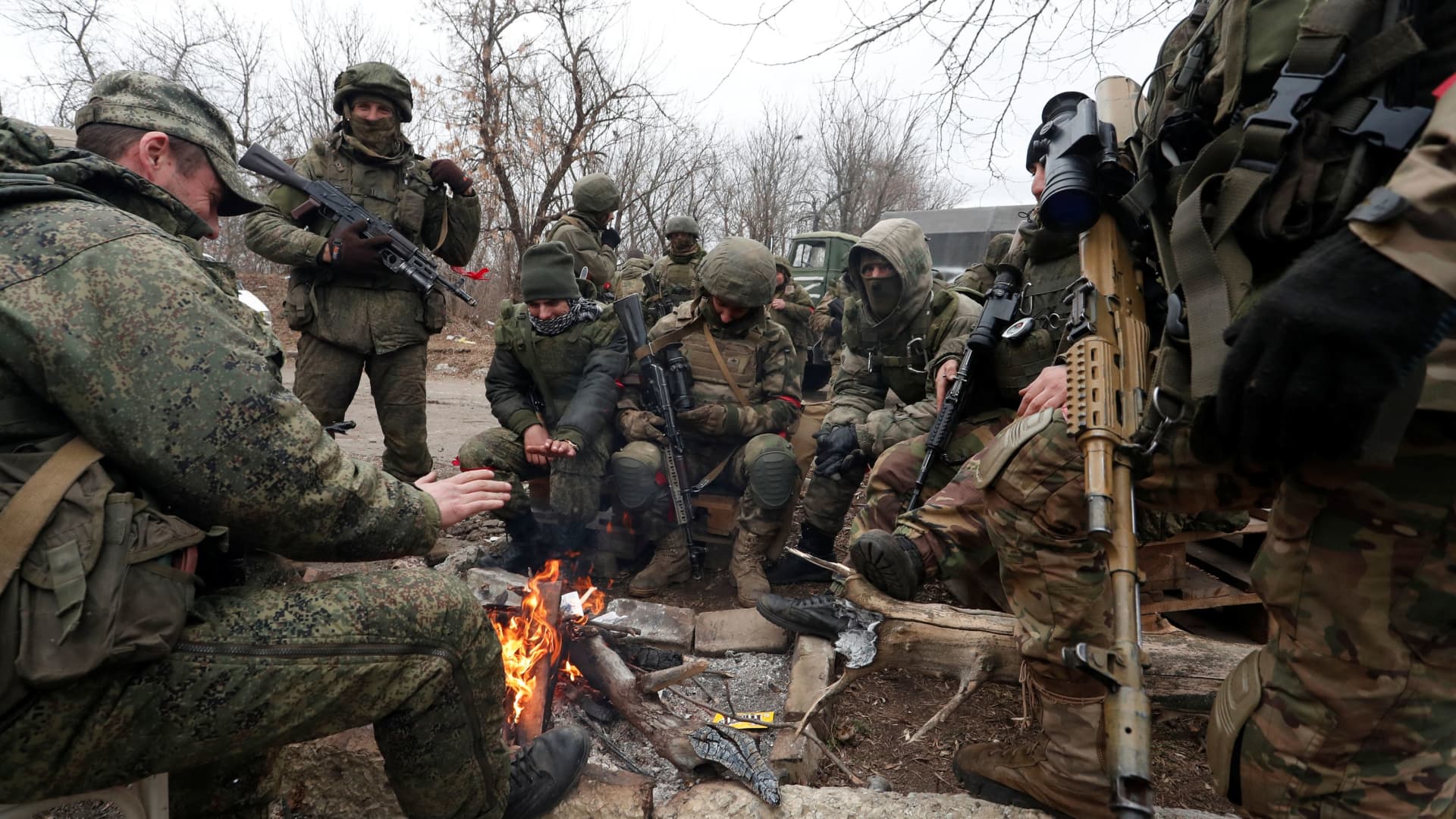 Service members of pro-Russian troops in uniforms without insignia gather around a fire in the separatist-controlled settlement of Mykolaivka (Nikolaevka), as Russia's invasion of Ukraine continues, in the Donetsk region, Ukraine March 1, 2022.
