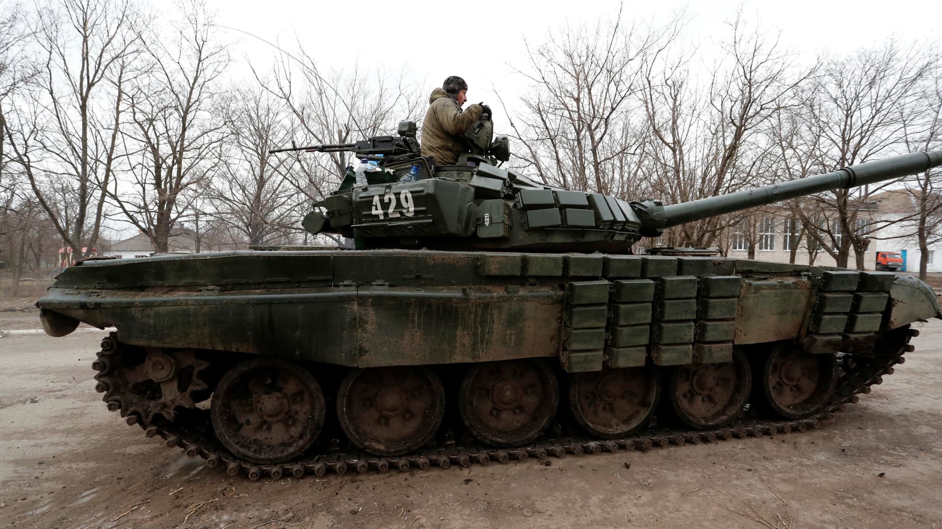 A service member is seen atop of a tank while pro-Russian troops gather in the separatist-controlled settlement of Mykolaivka (Nikolaevka), as Russia's invasion of Ukraine continues, in the Donetsk region, Ukraine March 1, 2022.