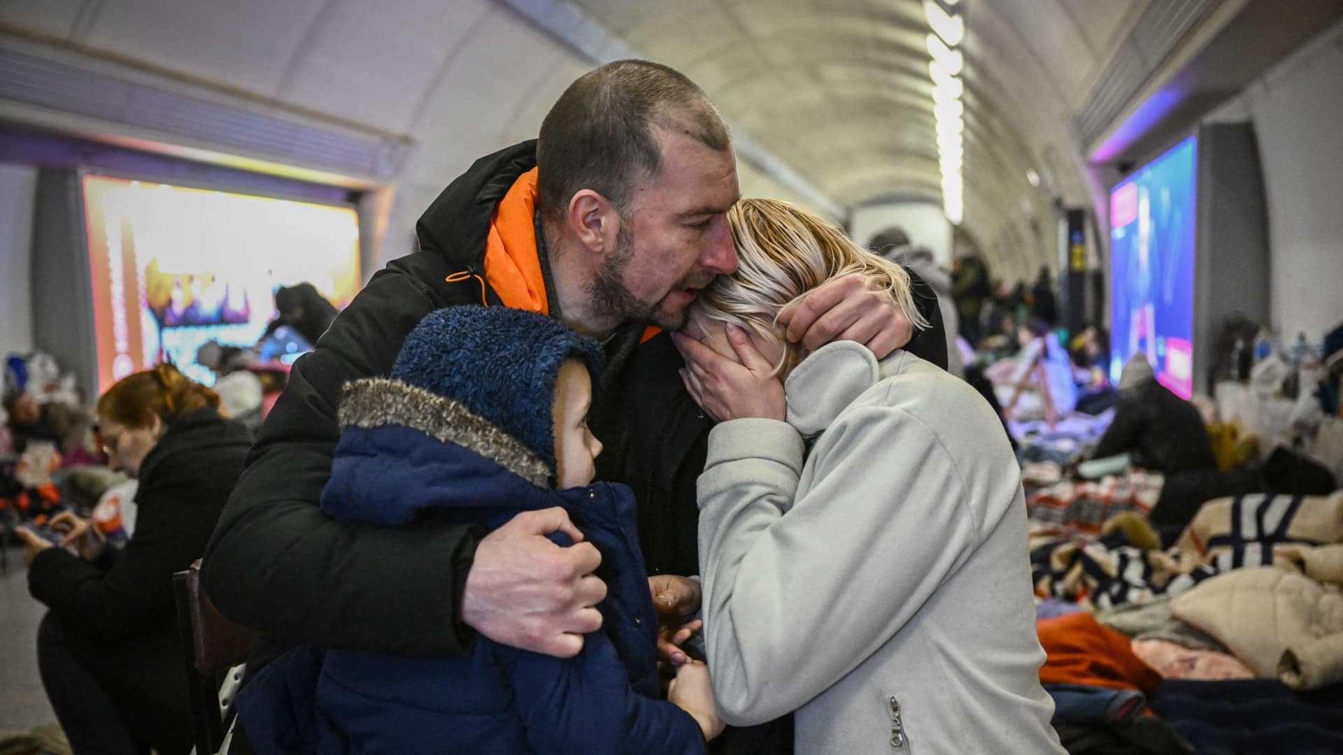 Sergyi Badylevych, 41, hugs his wife Natalia Badylevych, 42, and baby in an underground metro station used as bomb shelter in Kyiv on March 2, 2022.