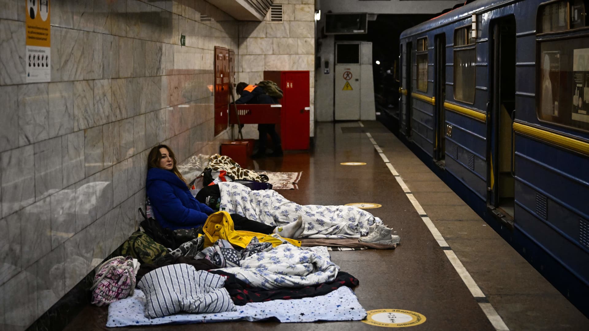 A woman sits in an underground metro station used as bomb shelter in Kyiv on March 2, 2022.