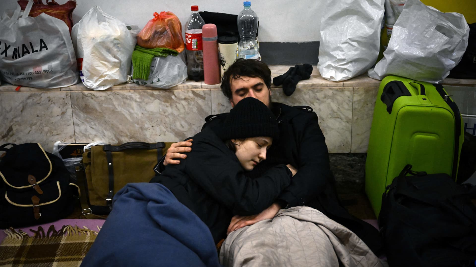 A couple sit in an underground metro station used as bomb shelter in Kyiv on March 2, 2022.