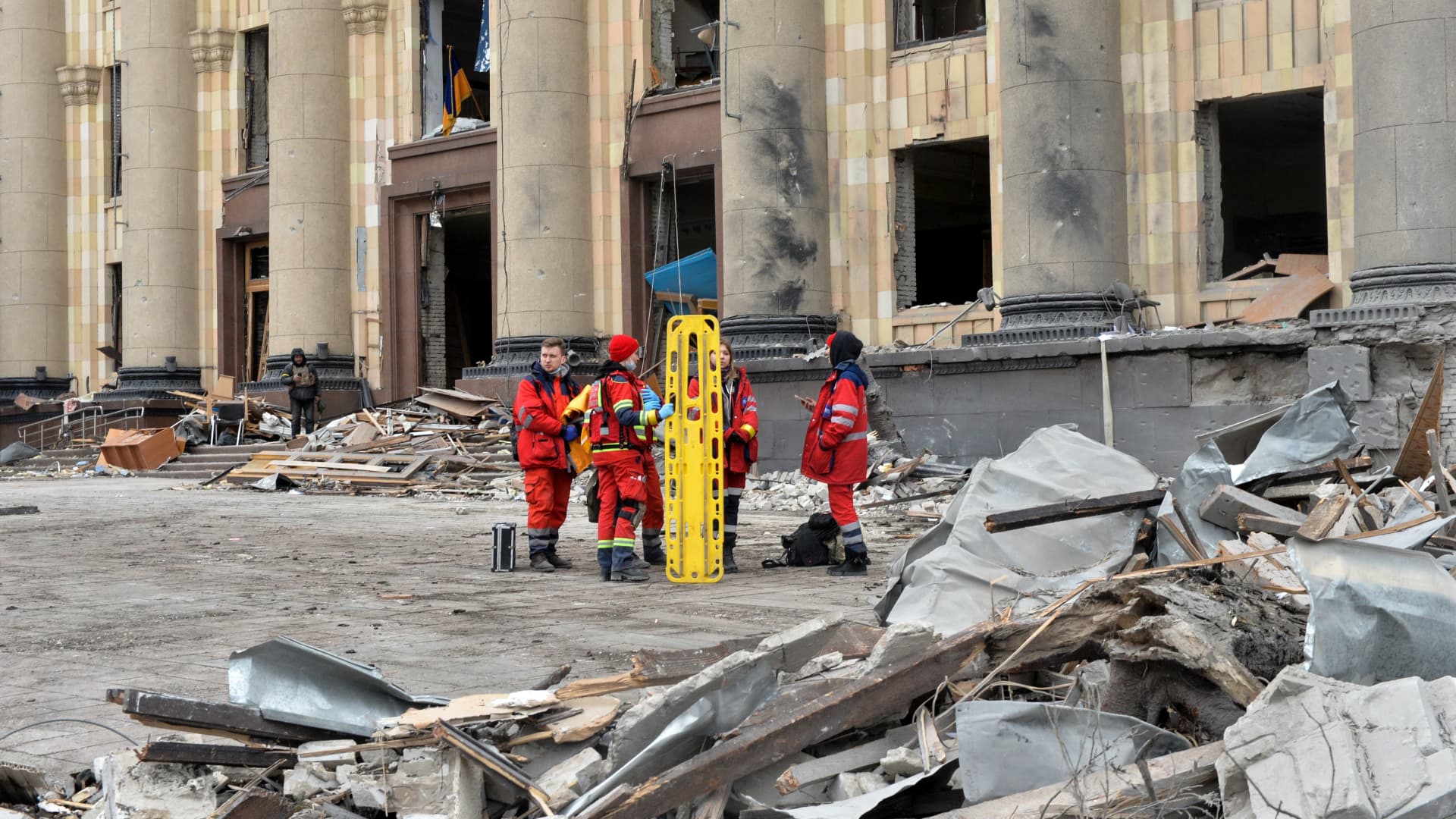 Medics stand outside the damaged local city hall of Kharkiv on March 1, 2022, destroyed as a result of Russian troop shelling.