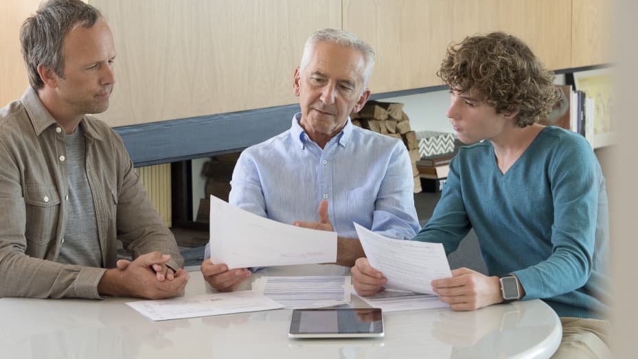 Father, grandfather and son review documents